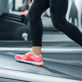 Person wearing pink shoes walking on an inclined treadmill